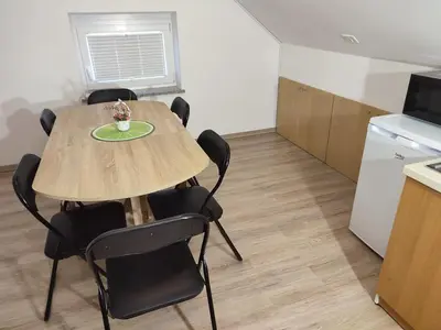 a kitchen and a table and chairs in a room at Apartment Jelovca - in the attic in Radovljica
