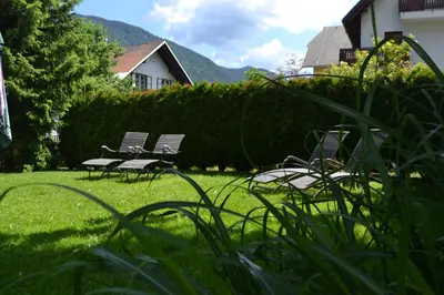 two benches sitting in the grass in a yard at Apartments Vijolica on the ski slope with free parking in Kranjska Gora