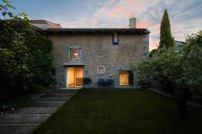 a large stone house with two doors and a yard at Kambra in Dutovlje