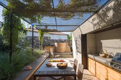 a patio with a table with a bowl of fruit on it at Kambra in Dutovlje