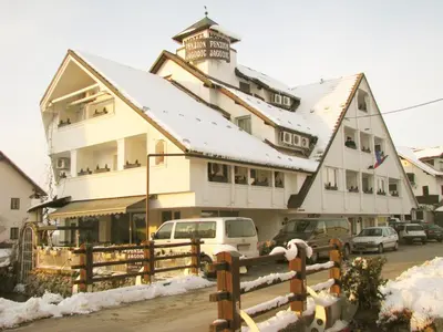 a building with a fence in front of it at Jagodic Garni Hotel in Cerklje na Gorenjskem