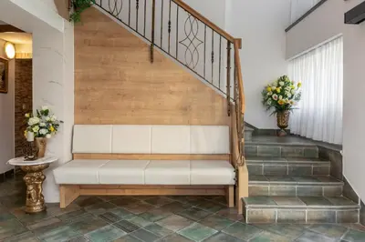 a bench in a hallway with stairs with flowers at Jagodic Garni Hotel in Cerklje na Gorenjskem