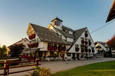 a large white building with a clock tower on top at Jagodic Garni Hotel in Cerklje na Gorenjskem