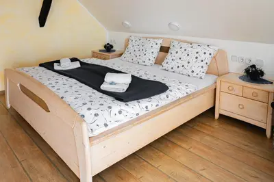 a bedroom with a wooden bed with two night stands at Slovenian Traditional Guest House in Begunje na Gorenjskem