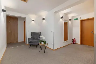 an empty hallway with a chair and a table at Gostilna Logar in Hotemaže