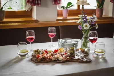 a plate of food on a table with glasses of wine at Gostilna Logar in Hotemaže
