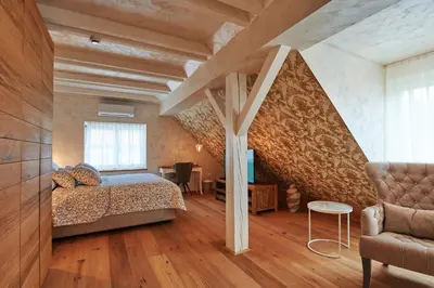 a bedroom with a bed and a chair in a room at Hiša Ančka, Boutique Hotel & Maja Rooms in Slovenj Gradec
