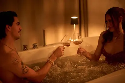 a man and woman in the bath tub with wine glasses at Hiša Ančka, Boutique Hotel & Maja Rooms in Slovenj Gradec