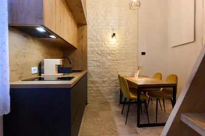 a small kitchen with a table and a counter top at Hiša Ančka, Boutique Hotel & Maja Rooms in Slovenj Gradec
