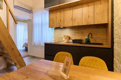 a kitchen with a wooden table and yellow chairs at Hiša Ančka, Boutique Hotel & Maja Rooms in Slovenj Gradec