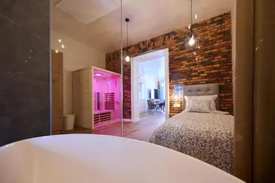 a bedroom with a bed and a brick wall at Hiša Ančka, Boutique Hotel & Maja Rooms in Slovenj Gradec