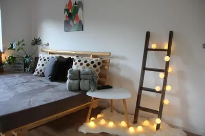 a bedroom with a bed with a ladder and a chair at Woodywood house Bohinj in Polje