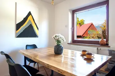 a dining room table with a vase of flowers on it at Woodywood house Bohinj in Polje