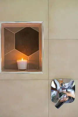 a candle sitting on a wall next to a mirror at Woodywood house Bohinj in Polje