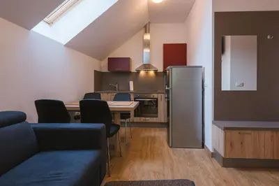 a living room with a table and a refrigerator at Apartments Dominika in Bohinjska Bela