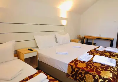a hotel room with two beds and two tables at Pension MOYCHI in Bled