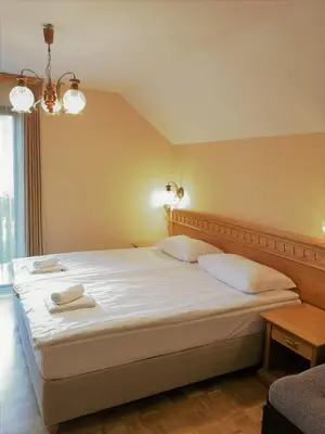 a bedroom with a large bed with two towels on it at Pension MOYCHI in Bled