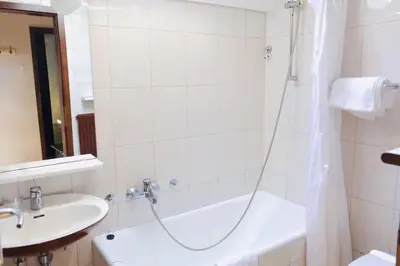 a bathroom with a shower and a tub and a sink at Pension MOYCHI in Bled