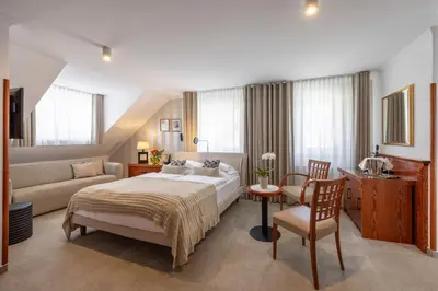 a hotel room with a bed and a couch at Kotnik Superior Boutique Hotel in Kranjska Gora