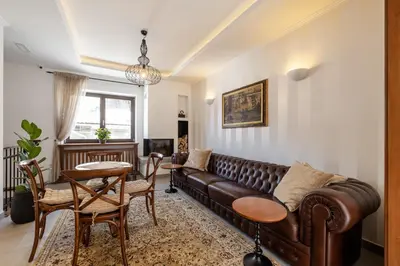 a living room with a brown leather couch and a table at Kotnik Superior Boutique Hotel in Kranjska Gora
