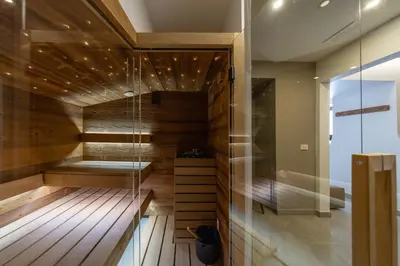 a sauna with wooden floors and a glass wall at Kotnik Superior Boutique Hotel in Kranjska Gora