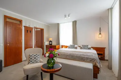 a bedroom with a bed and a vase of flowers on a table at Kotnik Superior Boutique Hotel in Kranjska Gora