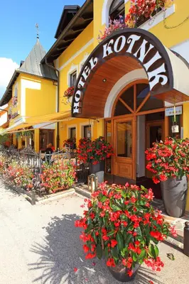 a restaurant with flowers in front of a building at Kotnik Superior Boutique Hotel in Kranjska Gora