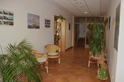 a hallway with chairs and plants in a room at Garni Hotel Villa Tamara in Moravske Toplice