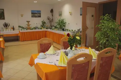 a dining room with a table with yellow table cloth at Garni Hotel Villa Tamara in Moravske Toplice