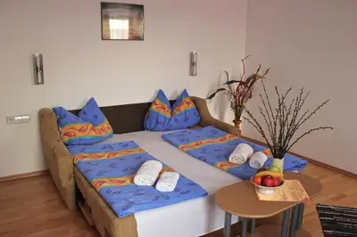 a room with a bed with pillows and a table at Garni Hotel Villa Tamara in Moravske Toplice