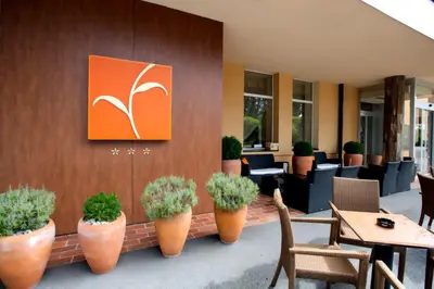 a restaurant with tables and chairs and plants on a wall at Ambient Hotel in Domžale