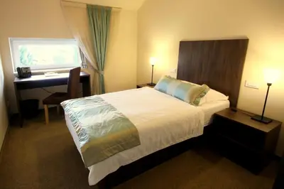 a bedroom with a bed and a desk and a desk at Ambient Hotel in Domžale