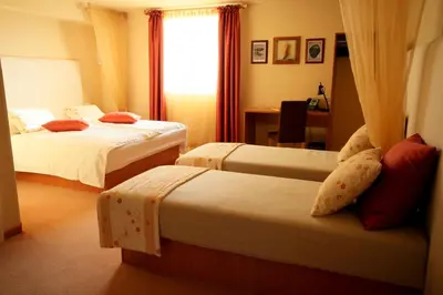 a hotel room with two beds and a window at Ambient Hotel in Domžale