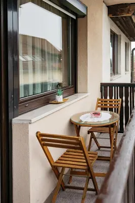 a balcony with two chairs and a table and a window at Apartments Šentvid in Ljubljana