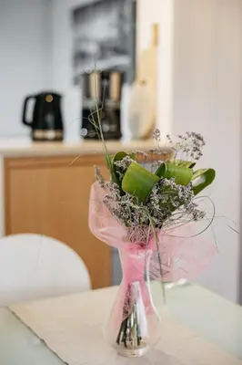 a vase with flowers in it on a table at Apartments Šentvid in Ljubljana