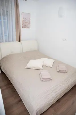 a white bed with two pillows on top of it at Apartments Šentvid in Ljubljana