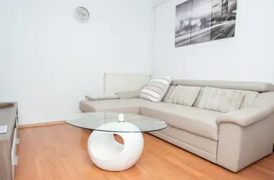 a living room with a white couch and a glass table at Apartments Šentvid in Ljubljana