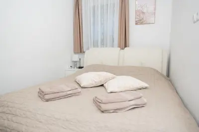 a bed with two pillows and two towels on it at Apartments Šentvid in Ljubljana