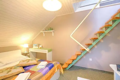 a small room with a bed and a staircase at Penzion Park in Laško