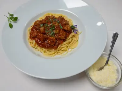 a bowl of spaghetti with meatballs and sauce on a plate at Penzion Park in Laško