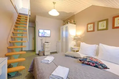 a bedroom with a bed and a spiral staircase at Penzion Park in Laško