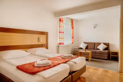 a bedroom with a large bed and a couch at Apartments Kristan in Bled