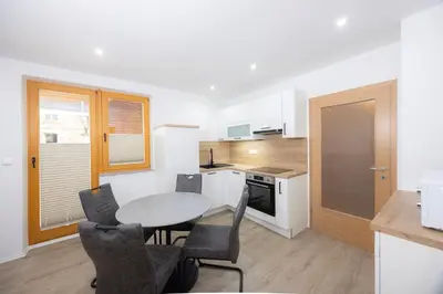 a kitchen with a table and chairs in a room at Apartment Arnika Kranjska Gora in Kranjska Gora
