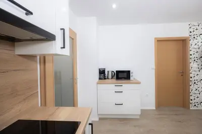 a kitchen with white cabinets and a microwave at Apartment Arnika Kranjska Gora in Kranjska Gora