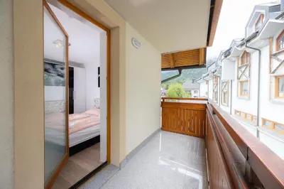 a room with a balcony with a bed and a window at Apartment Arnika Kranjska Gora in Kranjska Gora