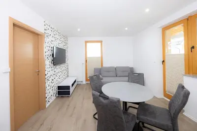 a living room with a table and chairs and a couch at Apartment Arnika Kranjska Gora in Kranjska Gora