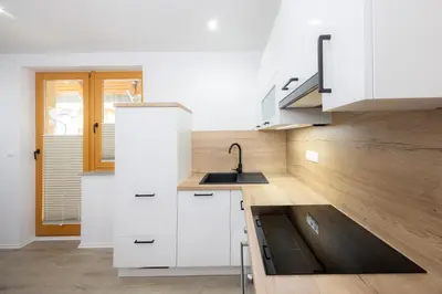 a kitchen with white cabinets and a sink at Apartment Arnika Kranjska Gora in Kranjska Gora