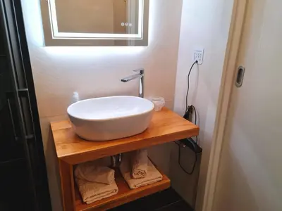 a bathroom with a white sink on a wooden table at Restaurant & Apartments Getaway Pri Kobalu in Vipava