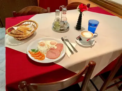 a table with a plate of food and a cup of coffee at Restaurant & Apartments Getaway Pri Kobalu in Vipava