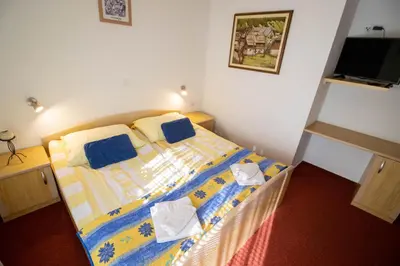 a bedroom with a bed with blue and yellow sheets at Rooms Cvitar - Center in Kranjska Gora
